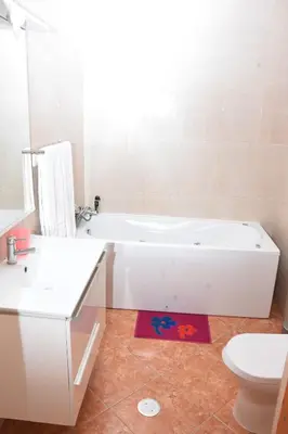a white bathroom with a tub and a toilet at Hot belvedere in Praia