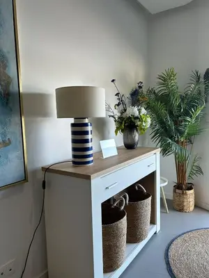 a lamp on a white table with plants on it at Ely's Place by the Sea in Praia Baixo