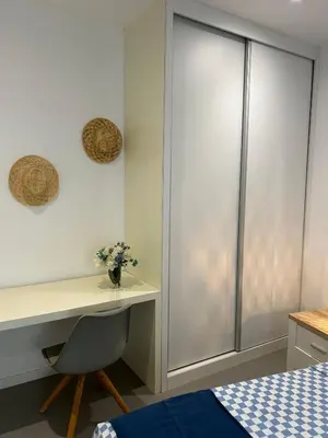 a bedroom with a desk with a chair and a bed at Ely's Place by the Sea in Praia Baixo