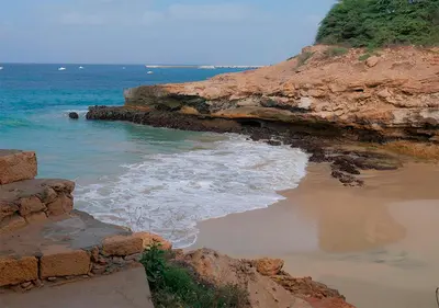 a beach with rocks and the water and the ocean at Appartamento Polvo. Stella Maris Exclusive in Calheta Do Maio