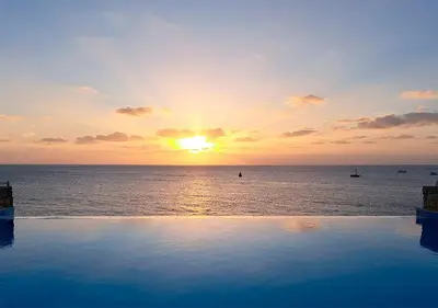 a sunset over the ocean with a swimming pool at Appartamento Serra. Stella Maris Exclusive in Calheta Do Maio