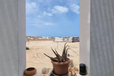a potted plant on a window sill with a view of the desert at Casa Vida Boa in Sal Rei