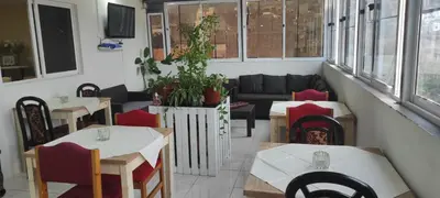 a restaurant with tables and chairs and a couch at guesthouse emaly in Mindelo