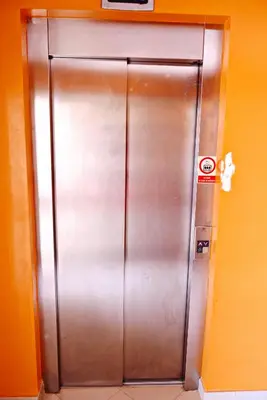 a large metal elevator in an orange wall at Mi Casa és Su Casa in Prainha