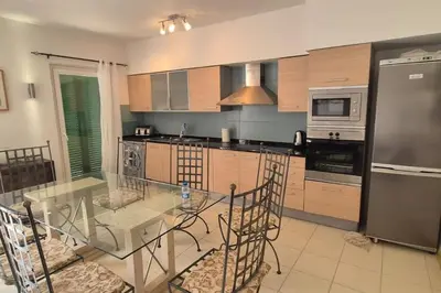 a kitchen with a glass table with chairs in it at SUNNY Apartment - SAL VILA VERDE - Cabo Verde in Santa Maria
