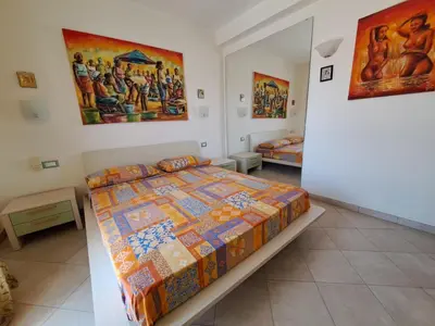 a bedroom with a bed and paintings on the wall at Sal service coquero in Santa Maria