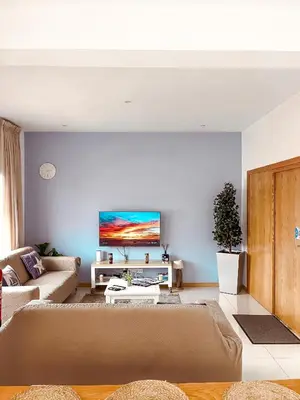 a living room with a couch and a tv on a wall at Boa Mindelo Beach in Mindelo
