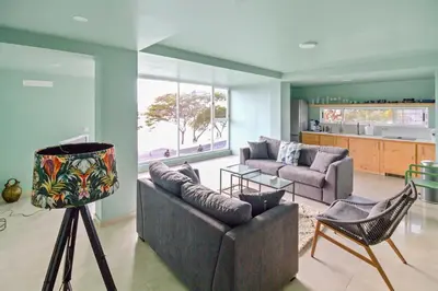 a living room with two couches and a kitchen at Sea-view Central Joy! in Mindelo