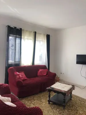 a living room with a red couch and a coffee table at Simple sunlight apartment - Assomada in Assomada