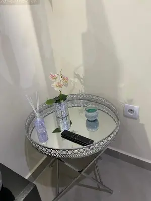 a glass table with vases and a remote control on it at T1 Férias Mindelo in Mindelo