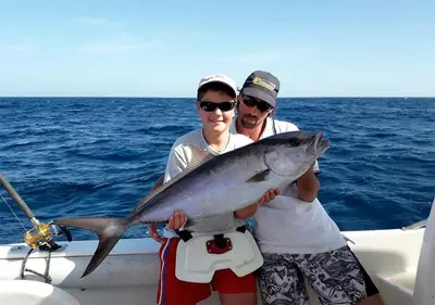 two people on a boat holding a fish at Villa Baleia Stella Maris Exclusive in Calheta Do Maio