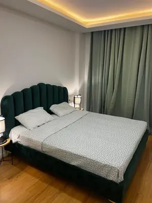 a bedroom with a large bed with a green headboard at ROYAL PALMAREJO APPARTAMENTO in Praia