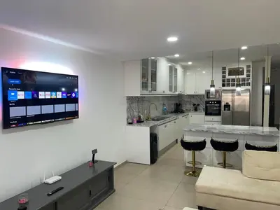 a kitchen with a tv on a white wall at Pinto’s in Praia