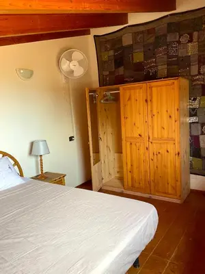 a bedroom with a bed and a wooden cabinet at Apartment Terrace - front sea view From - May till September in Santa Maria