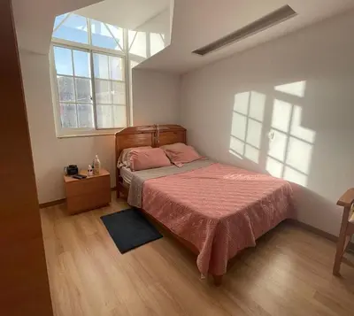 a bedroom with a bed with a red blanket and two windows at Casa Mendes- Quarto Casal in Praia