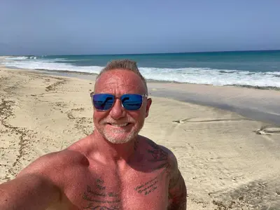 a man wearing sunglasses on the beach at Tortuga beach resort Penthouse apartment for holiday rental in Prainha