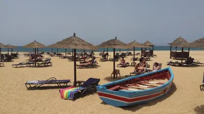 a boat on a beach with chairs and umbrellas at Tortuga beach resort Penthouse apartment for holiday rental in Prainha