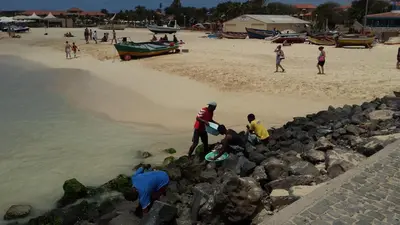 a group of people standing on the rocks at the beach at Tortuga beach resort Penthouse apartment for holiday rental in Prainha