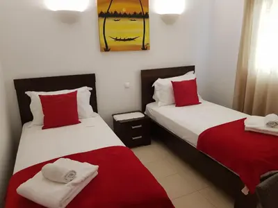 two beds in a room with red and white sheets at Tortuga beach resort Penthouse apartment for holiday rental in Prainha