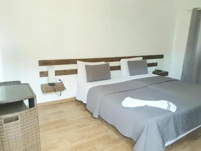 a bedroom with a large bed with a shoe on it at Hotel Salinas São Jorge in São Filipe