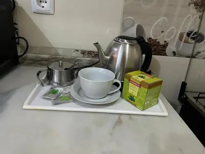 a tea pot and a cup on a tray on a kitchen counter at My Flat 0 in Praia