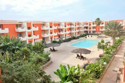 an apartment complex with a swimming pool and umbrellas at Nagoia's place com varanda, piscina e super wi-fi in Santa Maria