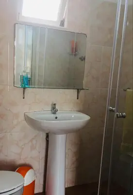 a bathroom with a sink and a mirror at Muralha Rooms in Mindelo