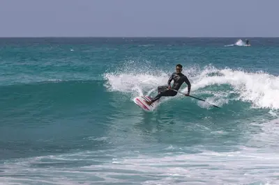 a man riding a wave on a surfboard in the ocean at Agua Hotels Sal Vila Verde in Santa Maria