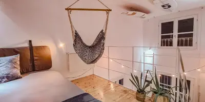a bedroom with a swing hanging from the wall at Chic Surf-Inspired Mezzanine Studio 