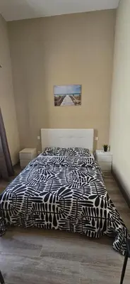 a bedroom with a bed with a black and white comforter at City Center Mindelo 39 in Mindelo