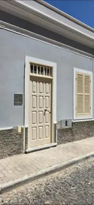 a white building with a door and a window at City Center Mindelo 39 in Mindelo
