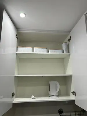 a bathroom with white shelves with towels and toiletries at Apartamento Ilhas in Praia
