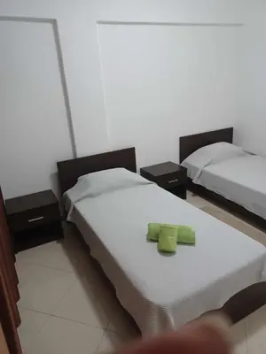 two beds in a room with two green towels at Gamboa Praia in Praia