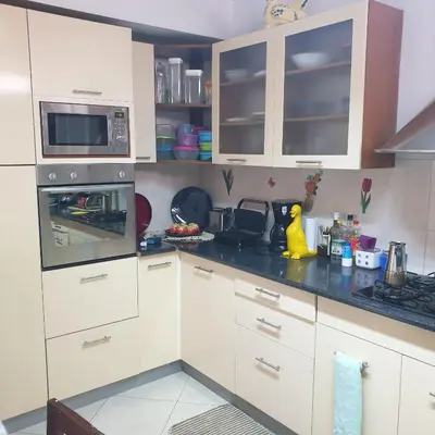 a kitchen with white cabinets and a black counter top at Gamboa Praia in Praia