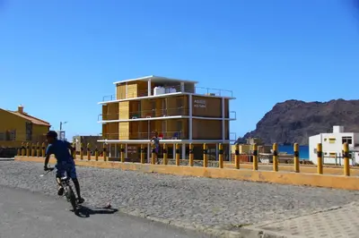 a man riding a bike in front of a building at Aquiles Eco Hotel in São Pedro
