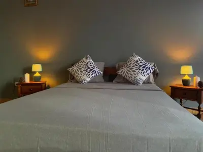 a bedroom with a large bed with two lamps at Huizenmarkt Caboverde in Mindelo