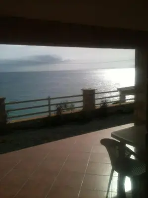 a bench sitting on a porch looking at the ocean at Villa 4 Stella Maris - Ilha do Maio in Vila do Maio