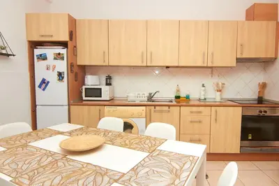 a kitchen with a table and a white refrigerator at Casa Irma in Santa Maria