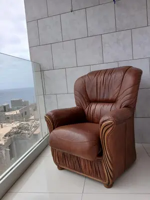 a brown leather chair sitting next to a window at Casa Cantinho d`ouro in Ponta do Sol