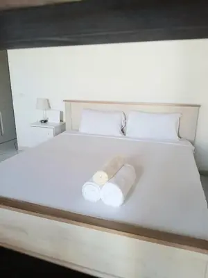 a bed with two rolled up towels on it at Santa Maria Homely Flat in Santa Maria