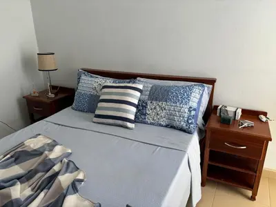 a bedroom with a bed with blue and white pillows at City Center Near Beach B&B in Tarrafal