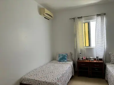 a small bedroom with two beds and a window at City Center Near Beach B&B in Tarrafal