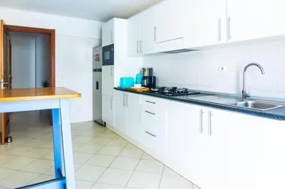 a kitchen with white cabinets and a sink at Bliss Apartments - T2 Nicole in Mindelo