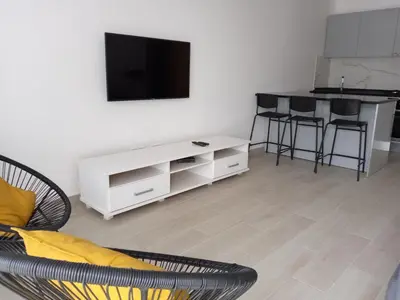 a living room with a white couch and a tv at Charming House Tarrafal in Tarrafal