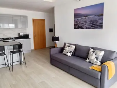 a living room with a couch and a kitchen at Charming House Tarrafal in Tarrafal
