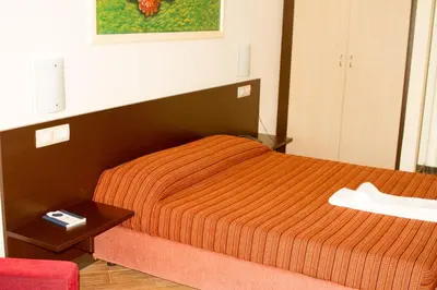 a bedroom with a bed with an orange comforter at Hotel Santantao Art Resort in Porto Novo