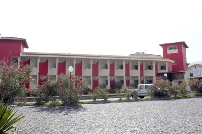 a large red and white building with a courtyard at Hotel Santantao Art Resort in Porto Novo