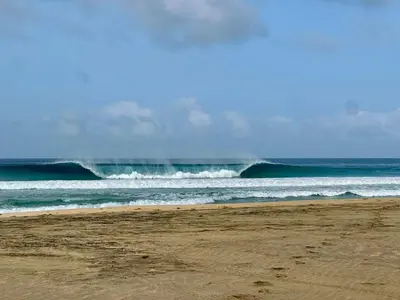 a beach with a large wave in the ocean at Serra's Village in Vila do Maio