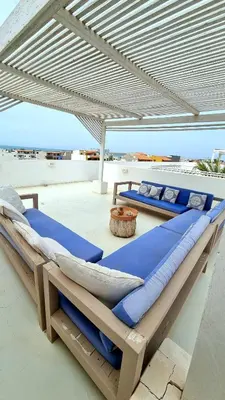 two beds under an umbrella on a patio at Surf House Casa Vehla in Sal Rei