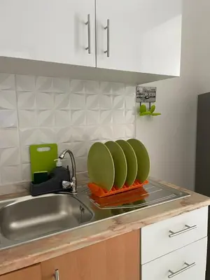 a kitchen counter with a sink with green dishes at Casa do Encanto in Praia